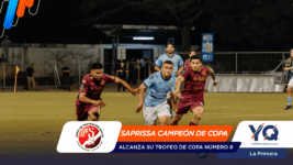 Soccer players in blue and maroon chase the ball on a night-time field while a bright banner at the bottom reads 'SAPRISSA CAMPEÓN DE COPA' with logos on left and right.