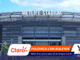Front view of MetLife Stadium with a large METLIFE STADIUM sign and modern façade, with colorful graphic overlays at the bottom left.