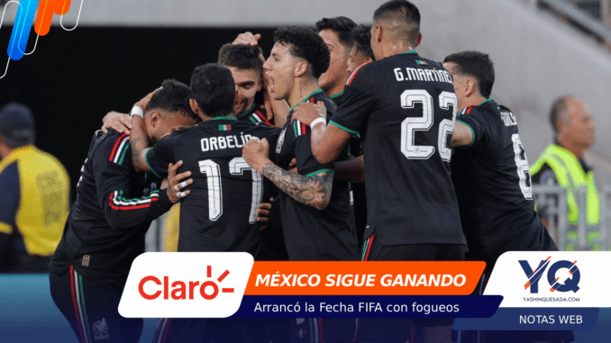Mexican national football team players celebrate in a huddle on the field, arms around each other.