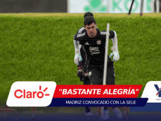 Soccer goalkeeper in black kit and gloves practicing agility between white poles on a grassy field, during training session.