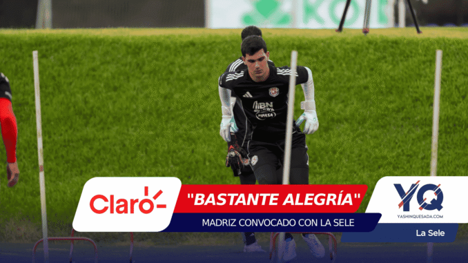 Soccer goalkeeper in black kit and gloves practicing agility between white poles on a grassy field, during training session.