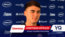 Portrait of a young man in front of a blue sponsor backdrop with logos, overlaid by a red banner reading 'Amistosos Difíciles' and text 'Rivales: Colombia e Inglaterra'