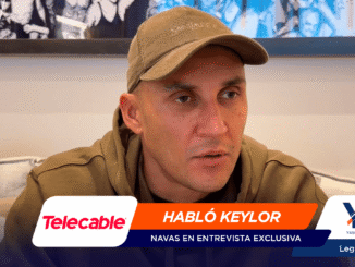Man in a brown hoodie and tan cap sits on a sofa during an interview thumbnail, with an orange banner 'HABLÓ KEYLOR' and sponsor logos (Telecable, YQ).