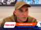 Man in a brown hoodie and tan cap sits on a sofa during an interview thumbnail, with an orange banner 'HABLÓ KEYLOR' and sponsor logos (Telecable, YQ).