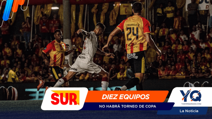 Soccer players in yellow-red and white jerseys compete for the ball on a crowded stadium field, with colorful sponsor banners at the bottom.