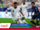 Soccer match: Saudi Arabia player wearing white with number 10 controls the ball as a blue-clad opponent pursues, with sponsor graphics overlay at the bottom.