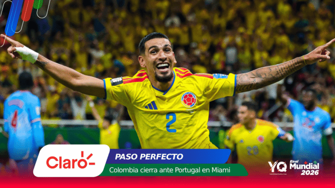 Colombian soccer player in a yellow jersey with arms outstretched, celebrating on the field with a cheering crowd in Miami behind him.