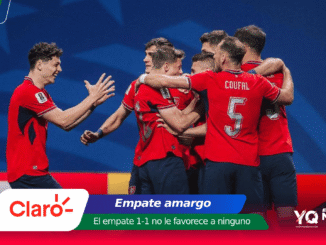 Soccer players in red jerseys celebrate together on a blue stadium background.