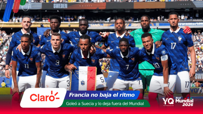 France national football team posing for a group photo on the pitch in blue jerseys with a stadium crowd in the background, after a match.