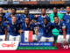 France national football team posing for a group photo on the pitch in blue jerseys with a stadium crowd in the background, after a match.