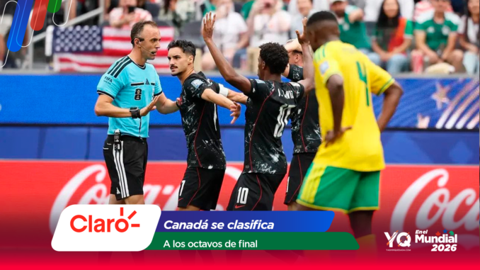 Soccer players celebrate together near a referee on a crowded field, with colorful banners in the foreground and a Coca‑Cola ad visible behind them.