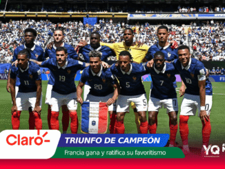 Equipo de fútbol de Francia posa para una foto de victoria en un estadio lleno, con pancartas y anuncios publicitarios alrededor (Triunfo de Campeón).