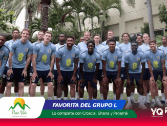 Group photo of soccer players in light-blue uniforms posing outdoors among palm trees.