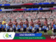 Soccer players stand in a line with hands over their chests during the national anthem in a full stadium, with USA FAVORITO and Mundial 2026 banners visible.