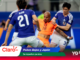 Futsal players in blue and orange clash for the ball during a match, with promotional banner text reading 'Países Bajos y Japón' and 'Se reparten puntos' in the foreground.