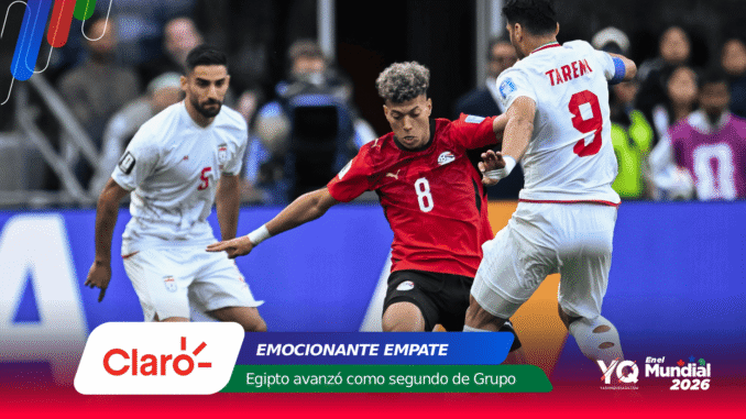 Soccer players in red and white battle for the ball on a stadium field, with colorful sponsor banners across the bottom.