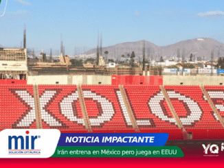 Wide view of a stadium with red seating forming a white mosaic, a construction site and distant hills under a blue sky; a colorful news banner overlays the bottom edge with logos and text.
