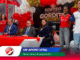Panel of six people seated or standing behind a red-and-white table during a formal event, with colorful balloons and a backdrop banner in Spanish that reads 'SORTEO EXTRAORDINARIO' and 'UN APOYO VITAL'.