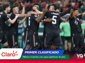 Mexico national soccer team players celebrate together on the field, hugging and cheering after a goal or win, in black kits with green red accents.