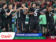 Mexico national soccer team players celebrate together on the field, hugging and cheering after a goal or win, in black kits with green red accents.