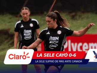 Two female soccer players in black jerseys run on a field during a match, with a large red sponsor banner overlay at the bottom.