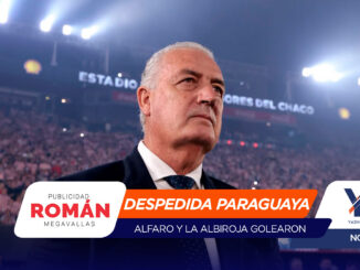 Man in a suit at a packed stadium during a farewell event; foreground banner reads 'Despedida Paraguaya' with crowd in the background.