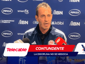 Man speaking at a press conference, microphones in front, blue sponsor backdrop behind him (logos like PIPASA, smartFit, MBN).
