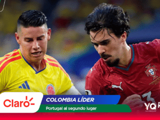 Two soccer players, one in a Colombia yellow jersey and the other in Portugal red, contest the ball in action on the field with sponsor banners overlaying the image.