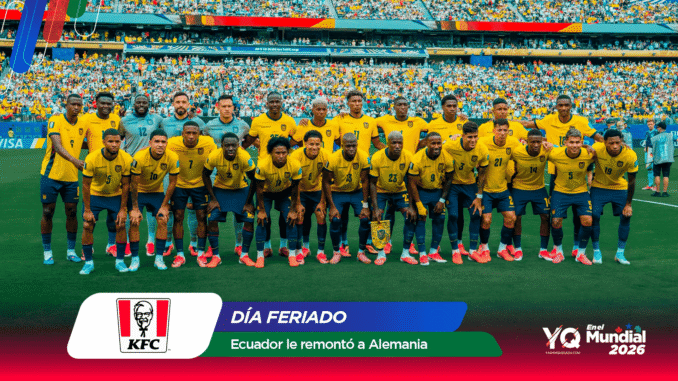 Ecuador national soccer team wearing yellow jerseys and blue shorts posing for a group photo on the pitch with a full stadium in the background.