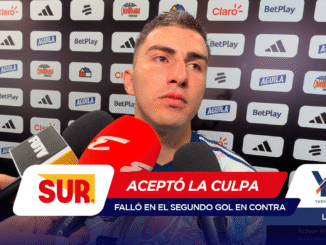 Man giving a post-match interview with multiple microphones in front of him; sponsor logos on a backdrop behind him.