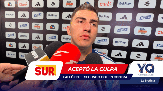 Man giving a post-match interview with multiple microphones in front of him; sponsor logos on a backdrop behind him.