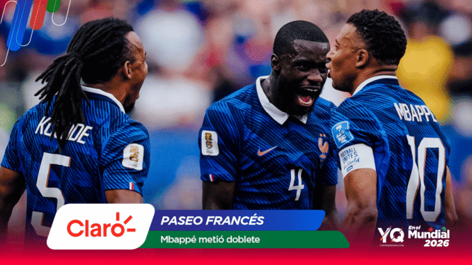 Three French football players in blue jerseys celebrate on the pitch, backs to the camera, faces lit with smiles amid a blurred crowd and sponsor banners at the bottom.