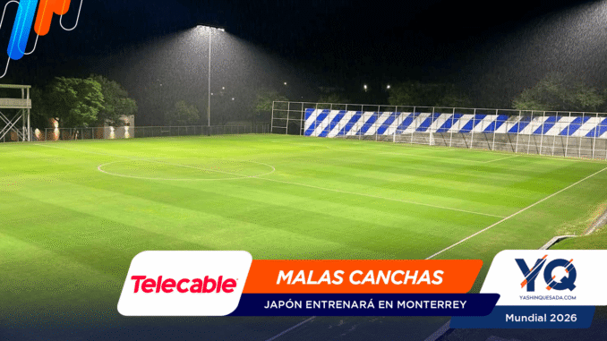 Soccer field at night illuminated by floodlights with advertising banners along the edge of the pitch.