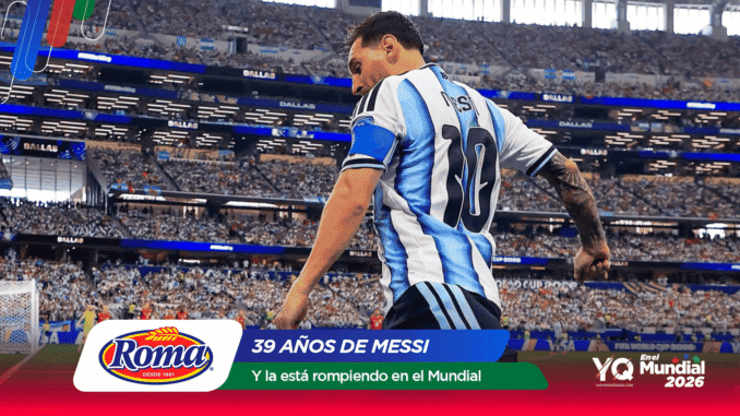 Soccer player in a blue-and-white striped jersey on a packed stadium field with Roma and Mundial 2026 banners in view.