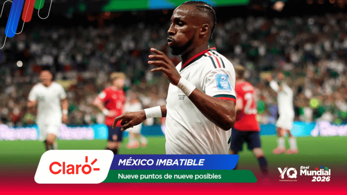 Soccer player in a white jersey on a crowded field with colorful sponsor banners at the bottom reading Claro and México Imbatible.