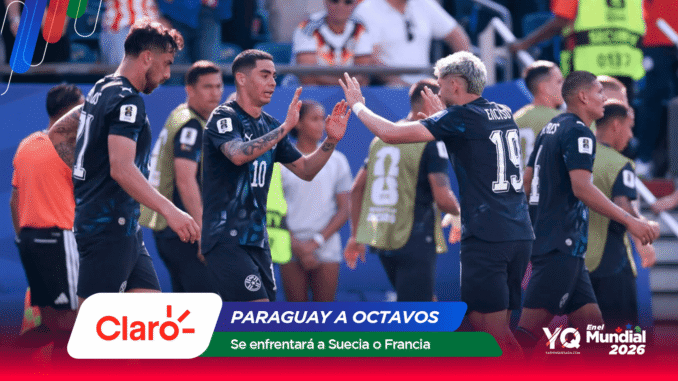 Soccer players in dark uniforms high-five as they celebrate on the field with banners in the foreground.