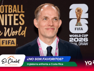 Portrait of a smiling man in a dark suit and pink lanyard at a FIFA World Cup 2026 event, with banners in the background reading 'Football Unites the World' and 'FIFA World Cup 2026'.
