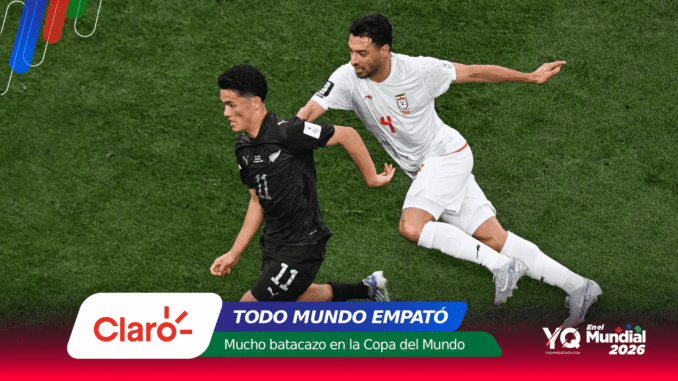 Two soccer players in black and white kits chase the ball on a green field, with sponsor banners at the bottom of the image.