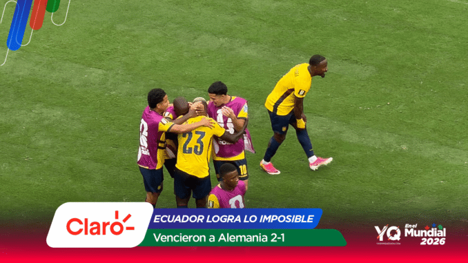 Group of soccer players in yellow and purple jerseys embrace in a huddle on a green pitch after a goal.