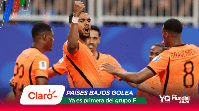 Dutch soccer players in orange celebrate on the field; central player raises a fist as teammates surround him, with banner text 'PAÍSES BAJOS GOLEA' and 'Ya es primera del grupo F'.