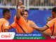 Dutch soccer players in orange celebrate on the field; central player raises a fist as teammates surround him, with banner text 'PAÍSES BAJOS GOLEA' and 'Ya es primera del grupo F'.