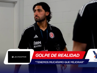 Man in a black polo with a CR crest, wearing a lanyard, standing in a hallway (team staff or player).