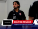 Man in a black polo with a CR crest, wearing a lanyard, standing in a hallway (team staff or player).
