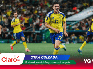 Soccer player in yellow and blue (number 17) runs toward the camera on a green pitch during a match, with blurred crowd in the background.