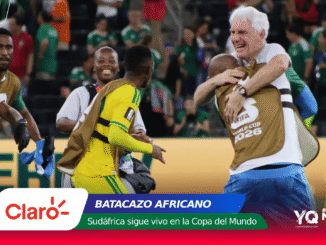 Soccer players in yellow uniforms celebrate on the field as a white-haired man hugs a teammate; bottom shows Claro banner and World Cup 2026 branding.