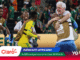 Soccer players in yellow uniforms celebrate on the field as a white-haired man hugs a teammate; bottom shows Claro banner and World Cup 2026 branding.