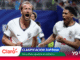 England footballers celebrate a goal, shouting with arms raised on the pitch, white kits with crest visible.