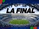 Wide aerial view of a soccer stadium with a bold 'LA FINAL' banner across the sky above empty seats and a green pitch.