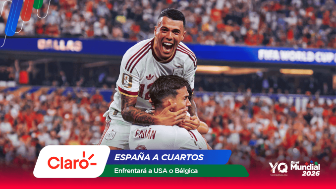 England footballers celebrate a goal, lifting a teammate amid a packed stadium and sponsor banners nearby.