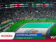 Crowded stadium during a FIFA World Cup 2026 event, with a turquoise pool on the field and colorful banners overhead.